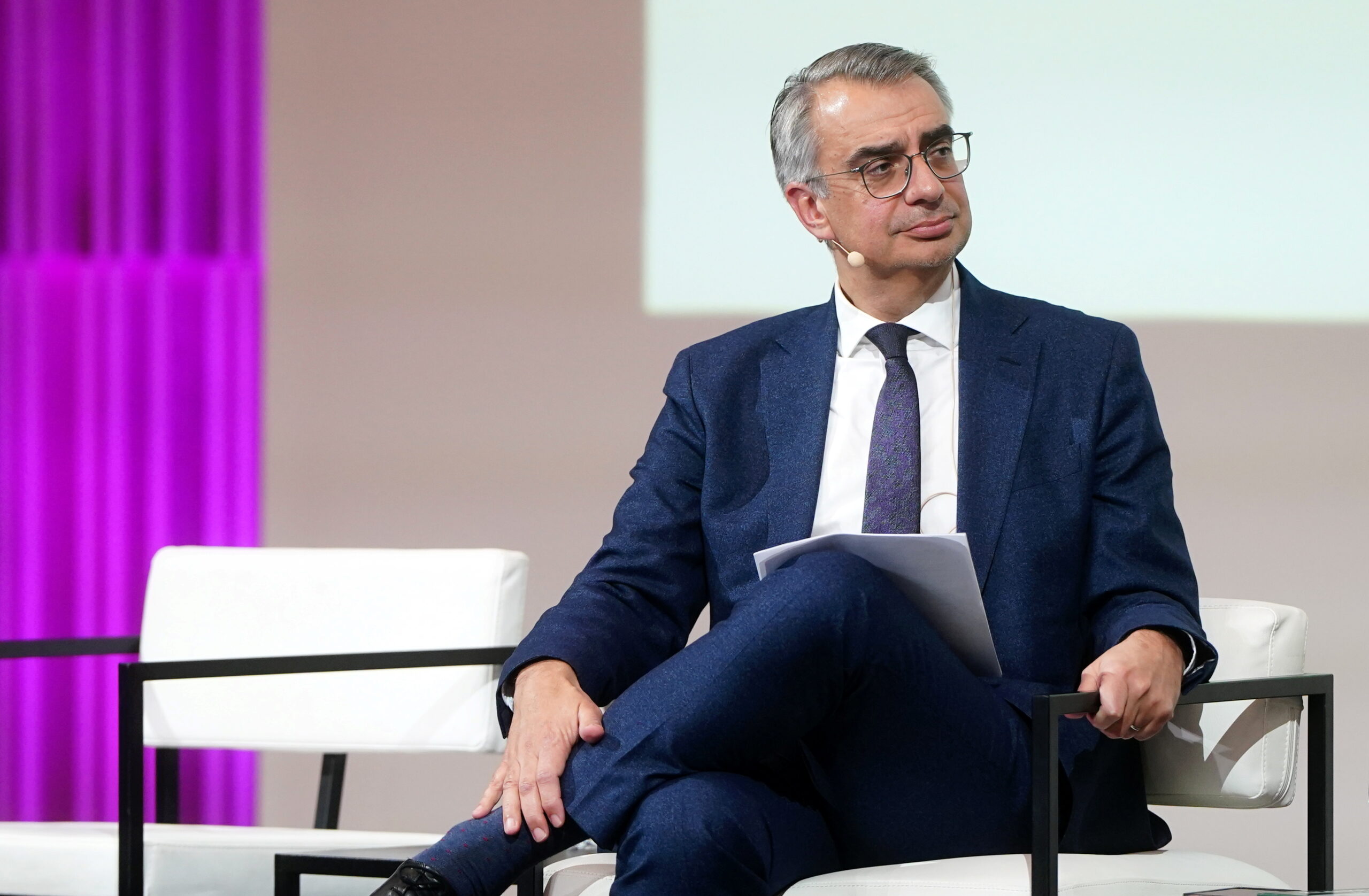 man sitting on stage in a conference setting